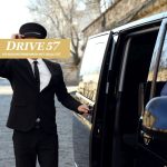 Diskreter Chauffeur von Drive 57 öffnet die Tür eines VIP-Fahrzeugs in Berlin.
