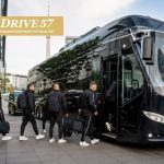 Sportmannschaft steigt in Berlin mit Gepäck in den Teambus von Drive 57 ein